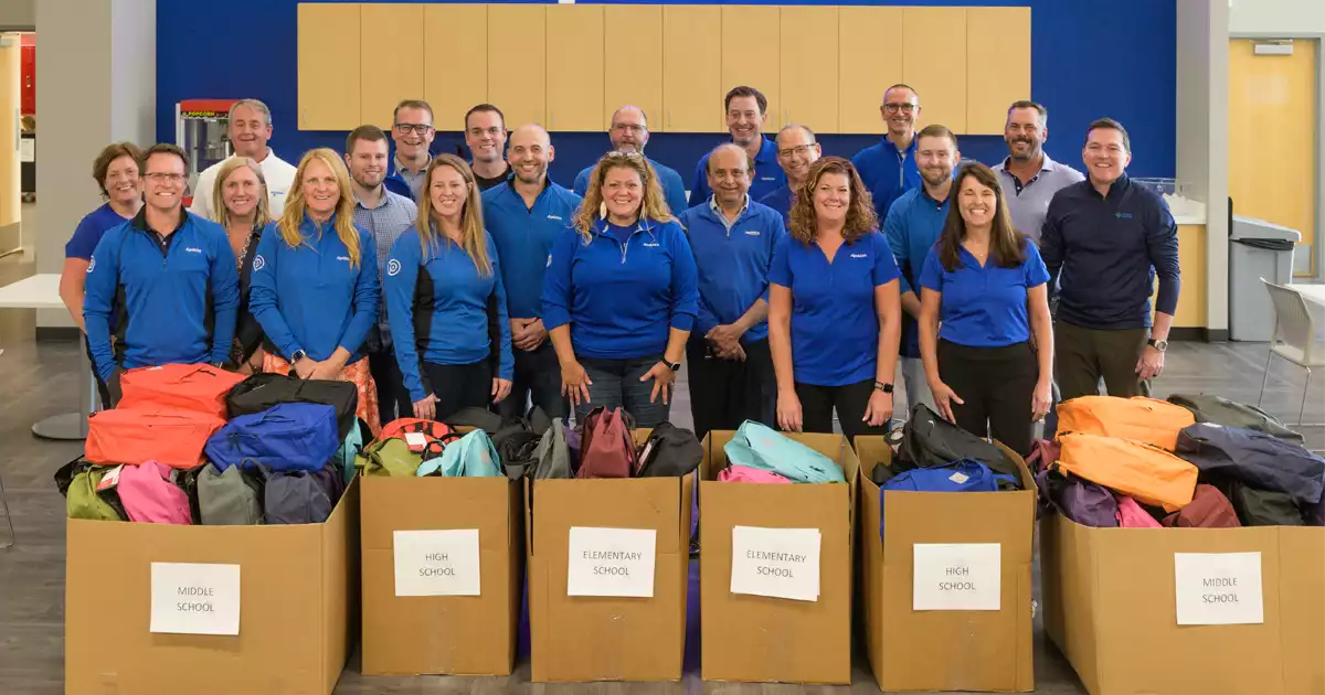 executives fill backpacks for madison-area students